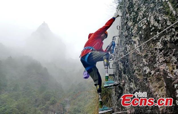 Double amputee Xia Boyu attempts a via ferrata climbing route at Shenxianju, a geological site known for its cliffs and waterfalls, in Taizhou City, East China\'s Zhejiang Province, Jan. 14, 2019. A via ferrata is a protected climbing route. Xia became a double amputee after suffering severe frostbite in both feet while attempting to climb Mount Qomolangma in 1975. The 70 year old scaled the world\'s highest peak as the first double amputee climber from the Nepali side on May 14, 2018. (Photo: China News Service/Ying Jianfei)