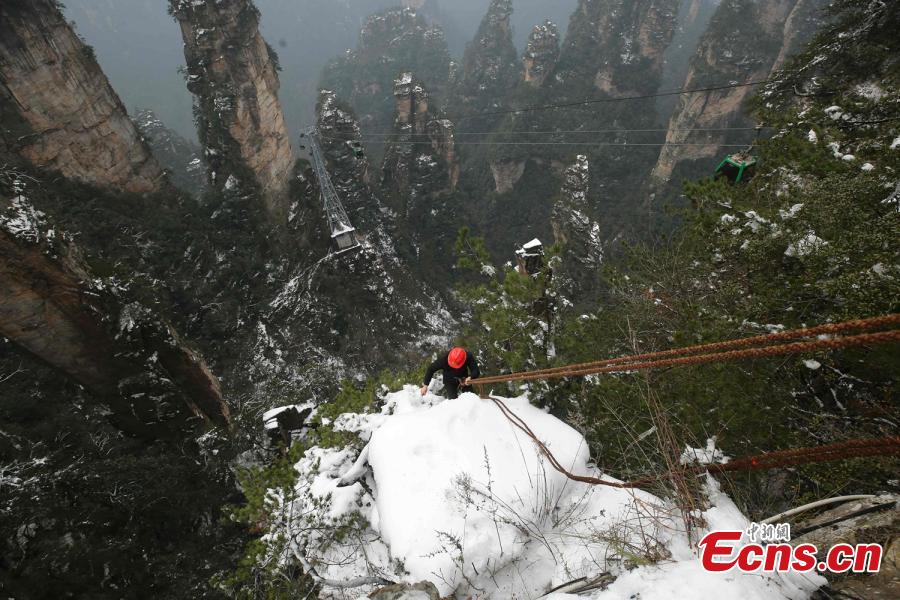 <?php echo strip_tags(addslashes(Su Songyun braves the winter cold to abseil down a cliff face and collect rubbish at the Huangshizhai scenic area in Zhangjiajie City, Central China's Hunan Province, Jan. 15, 2019. The 34-year-old local farmer began learning the stunt from his father in 2005, and his daredevil antics entertain tourists and enable him to collect garbage otherwise inaccessible on the mountain slope. (Photo: China News Service/Wu Yongbing))) ?>
