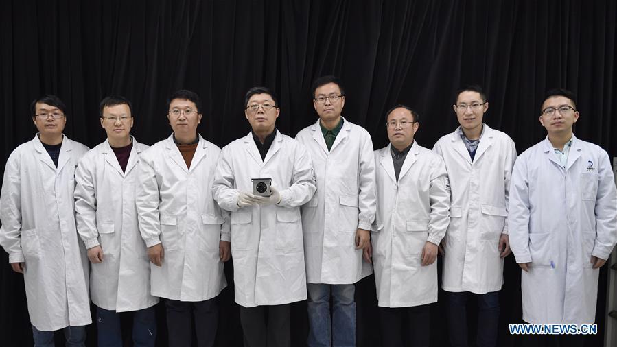 Staff members of Institute of Optics and Electronics of the Chinese Academy of Sciences pose for photos with a sample of the topographical camera installed on the lander of the Chang\'e-4 probe in Chengdu, southwest China\'s Sichuan Province, Jan. 17, 2019. The topographical camera installed on the lander of the Chang\'e-4 probe is responsible for both taking colorful high-resolution images on the lunar surface and monitoring the lunar rover Yutu-2. China\'s Chang\'e-4 lunar probe, comprising a lander and a rover, landed on the far side of the moon on Jan. 3, 2019. (Xinhua/Liu Kun)
