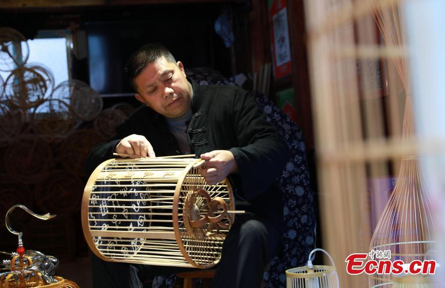Craftsman Wang Yuhe makes a bird cage-shaped lantern, to be used in Chinese New Year celebrations, in Kala Village, Danzhai County, Southwest China\'s Guizhou Province, Jan. 17, 2019. Wang is a master of the craft, recognized as an intangible cultural heritage by the province in 2008. The village is famous for producing bird cage-shaped lanterns. (Photo: China News Service/Huang Xiaohai)
