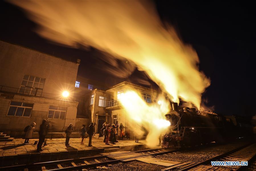 Visitors take pictures of a steam locomotive leaving Diaobingshan Station, northeast China\'s Liaoning Province on Jan. 17, 2019. A 5-day steam locomotive tourism event kicked off in Diaobingshan on Thursday. Tourists can visit the steam locomotive museum, take pictures of steam locomotives and watch exhibitions during the event. (Xinhua/Pan Yulong)