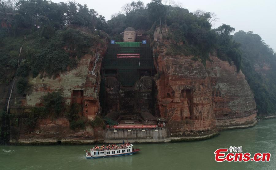 Photo taken on Jan. 17, 2019 shows the Leshan Giant Buddha statue undergoing restoration work in Leshan City, Southwest China\'s Sichuan Province. The 71-meter-tall statue, carved in the 8th century on a hillside overlooking the confluence of three rivers, is the largest Buddhist sculpture in the world. (Photo: China News Service/Liu Zhongjun)