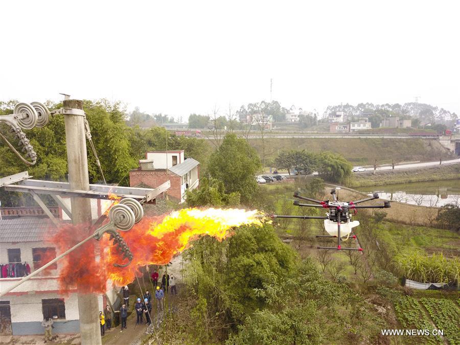 A flame-spurting drone destroys a hornet\'s nest on a wire pole in Xiaokan Village of Chongqing, southwest China, Jan. 16, 2019. The drone was developed by Chongqing\'s Yongchuan company of the State Grid corporation to help clear harmful obstacles hanging on overhead wires. (Xinhua/Liu Chan)