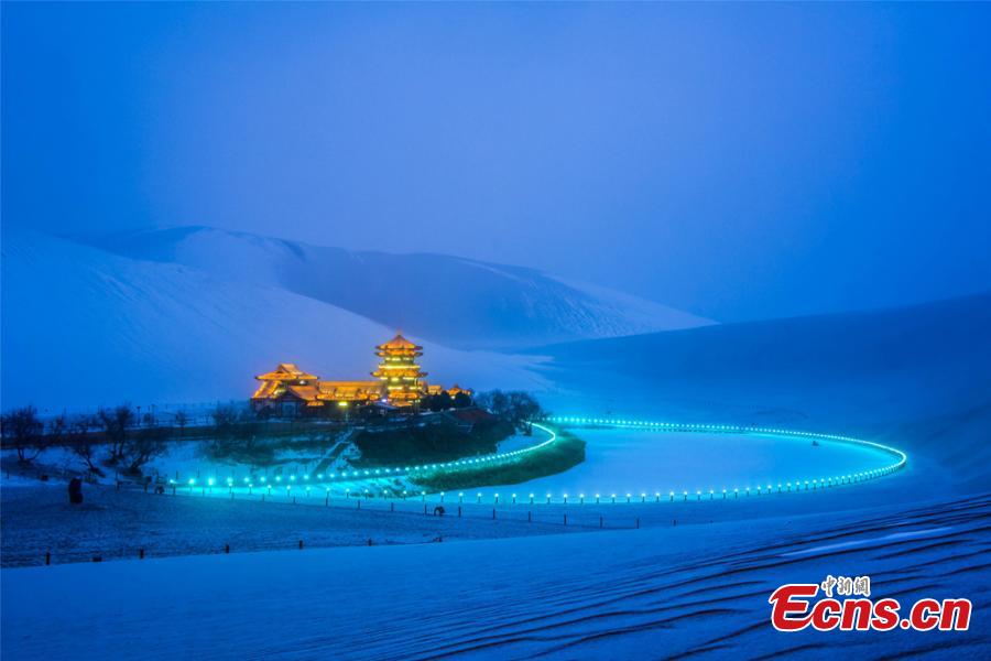 The Crescent Spring and Singing-Sand Dunes scenic spot in Dunhuang City, Northwest China\'s Gansu Province, after its first snow of the year, Jan. 19, 2019. Riding a camel across the desert landscape has become a popular activity for tourists to the area. (Photo: China News Service/Wang Binyin)