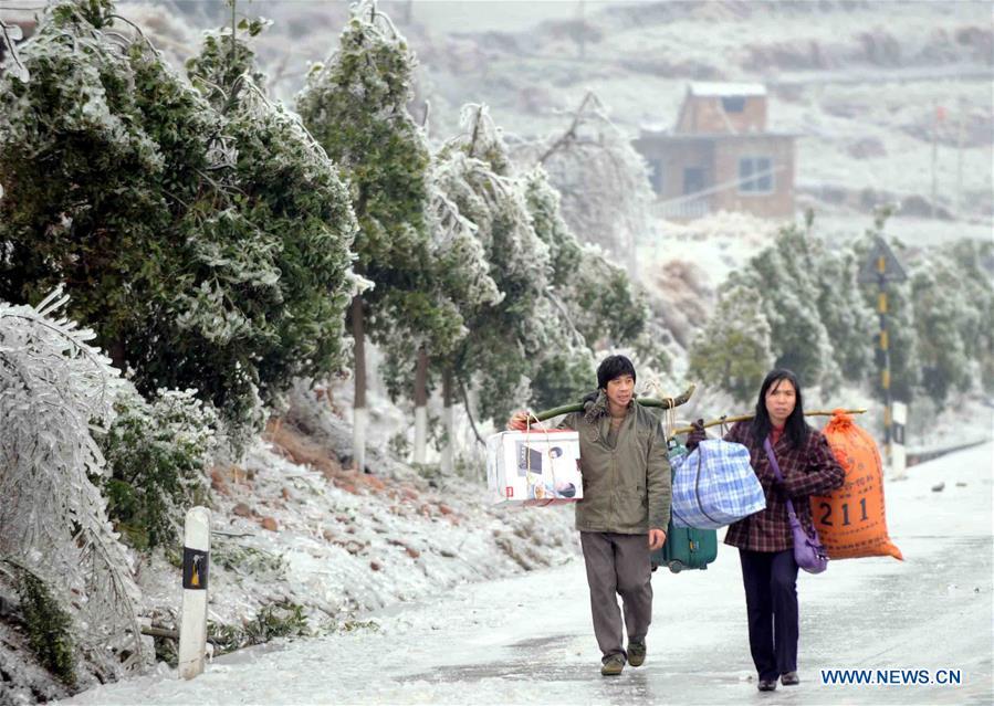 Pedestrians walk on a road closed due to heavy snow on their way home for the Spring Festival family reunion in Guanyang County of south China\'s Guangxi Zhuang Autonomous Region, Jan. 28, 2008. Returning to hometowns remains the most important part of the Chinese Spring Festival. Whether self-driving, or taking the trains or flights, homecomings and family gatherings are a priority for many Chinese. The annual travel rush around the festival, known as \