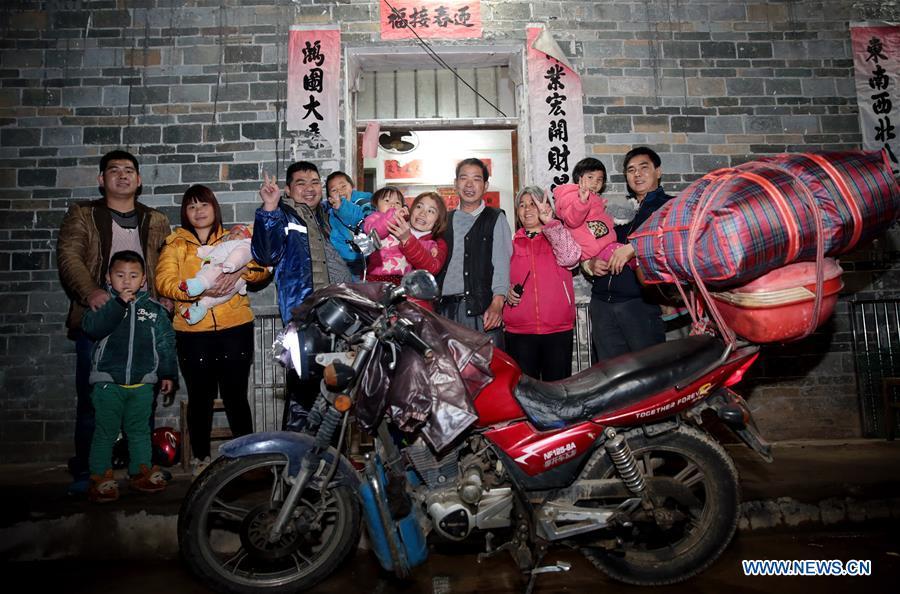 Migrant worker Chen Yifeng (8th, R) and his wife Xu lining (5th, R) pose for photos with their family after a 14-hour journey by motorcycle from Foshan, south China\'s Guangdong Province, to Pingding Village, Teng County of south China\'s Guangxi Zhuang Autonomous Region, Jan. 19, 2017. Returning to hometowns remains the most important part of the Chinese Spring Festival. Whether self-driving, or taking the trains or flights, homecomings and family gatherings are a priority for many Chinese. The annual travel rush around the festival, known as \