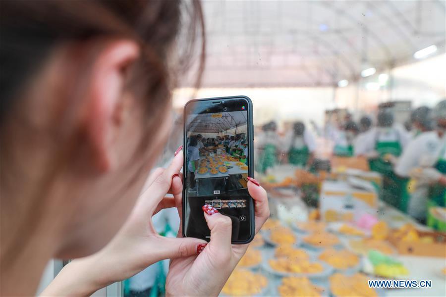 A tourist takes photos of the mango sticky rice in Bangkok, Thailand, Jan. 20, 2019. The rice was made of 1,500-kg sticky rice, 2,300-kg coconut juice and 5,000 mangoes. The total weight of the mango sticky rice reached 4,500 kilograms. The event aims to set a Guinness World Record for the largest serving of mango sticky rice. (Xinhua/Zhang Keren)