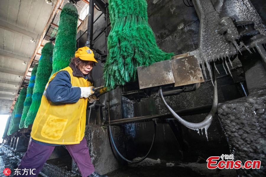 Female workers clean a train at a railway service station in Zhengzhou City, Central China\'s Henan Province. With an average age of 38 years, the workers in the cleaning unit are all female, with the exception of their male head. They are facing an increasing workload due to the Spring Festival travel rush, despite sub-zero temperatures. (Photo/IC)