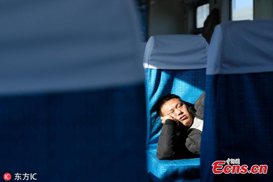 A passenger sleeps on a train traveling from Beijing to Zhuozhou in Hebei Province. (Photo/IC)