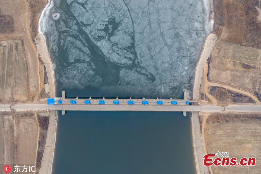 A view of a dam on the Majia River in Wudi County, East China\'s Shandong Province, Jan. 24, 2019. The horse cheek-shaped river dates back to the legendary Yu the Great some 4,000 years ago. Because of a water conservation project, the water is frozen on just one side. (Photo/IC)