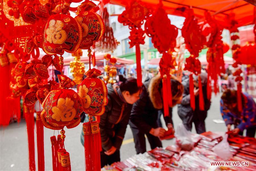 People select lunar new year decorations at a street market in Longli County, southwest China\'s Guizhou Province, Jan. 27, 2019. People across China are busy preparing for the upcoming Chinese Lunar New Year, which falls on Feb. 5 this year. (Xinhua/Long Yi)