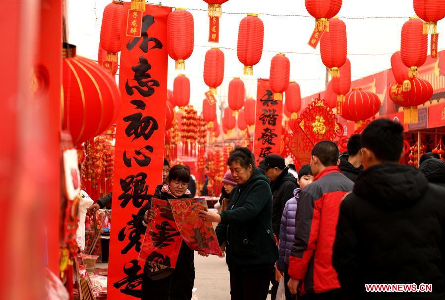 People select lunar new year decorations at a street market in Zhengding County of Shijiazhuang, north China\'s Hebei Province, Jan. 27, 2019. People across China are busy preparing for the upcoming Chinese Lunar New Year, which falls on Feb. 5 this year. (Xinhua/Chen Qibao)
