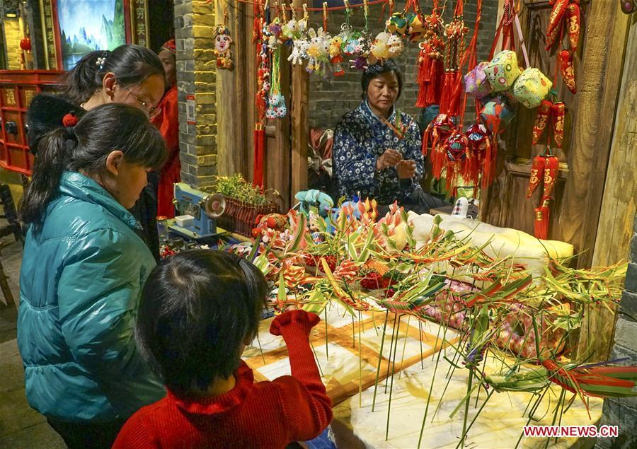 People select handicrafts on a food and culture street in Tangshan, north China\'s Hebei Province, Jan. 26, 2019. People across China are busy preparing for the upcoming Chinese Lunar New Year, which falls on Feb. 5 this year. (Xinhua/Liu Mancang)