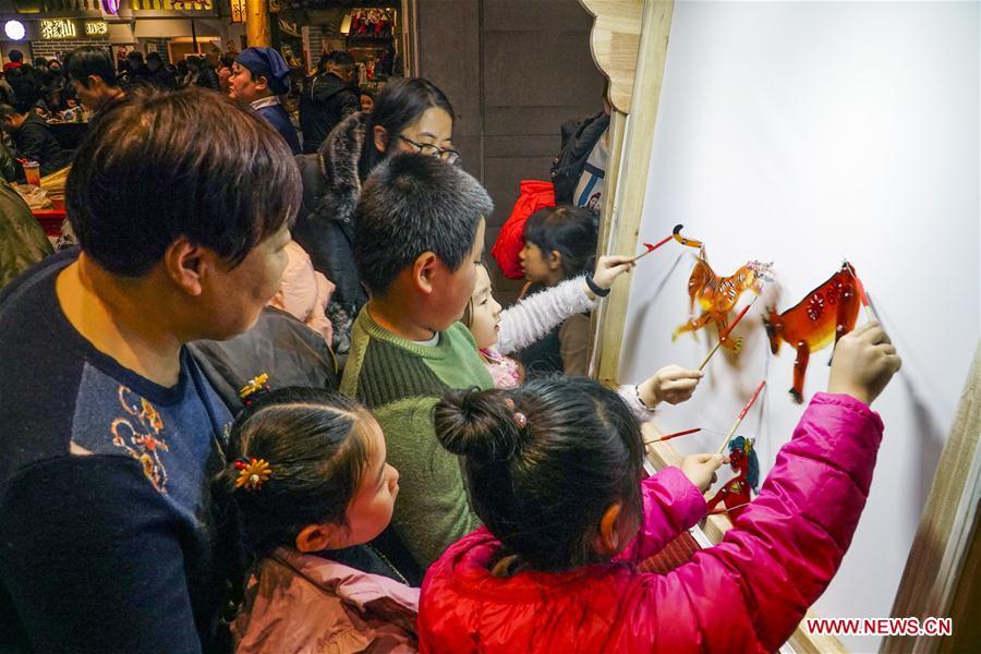 People experience piying opera, or shadow puppet performance, on a food and culture street in Tangshan, north China\'s Hebei Province, Jan. 26, 2019. People across China are busy preparing for the upcoming Chinese Lunar New Year, which falls on Feb. 5 this year. (Xinhua/Liu Mancang)
