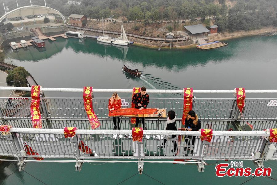 An event to welcome the Spring Festival is held on a suspended glass bridge over the Shiyan Lake in Changsha City, Hunan Province, Jan. 29, 2019. Surrounded by mountains, the lake is a popular tourist attraction. (Photo: China News Service/Yang Huafeng)