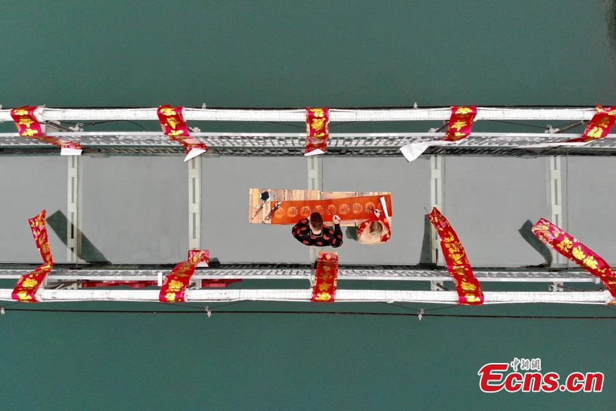 An event to welcome the Spring Festival is held on a suspended glass bridge over the Shiyan Lake in Changsha City, Hunan Province, Jan. 29, 2019. Surrounded by mountains, the lake is a popular tourist attraction. (Photo: China News Service/Yang Huafeng)