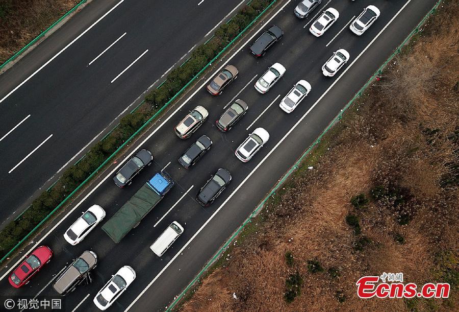 An aerial photo shows heavy traffic heading in one direction on an expressway while, in comparison, the opposite side of the road remains almost empty in Anhui Province. China is in the midst of its Spring Festival travel rush as millions of people go home for family reunions for the most important festival of the year. (Photo/VCG)
