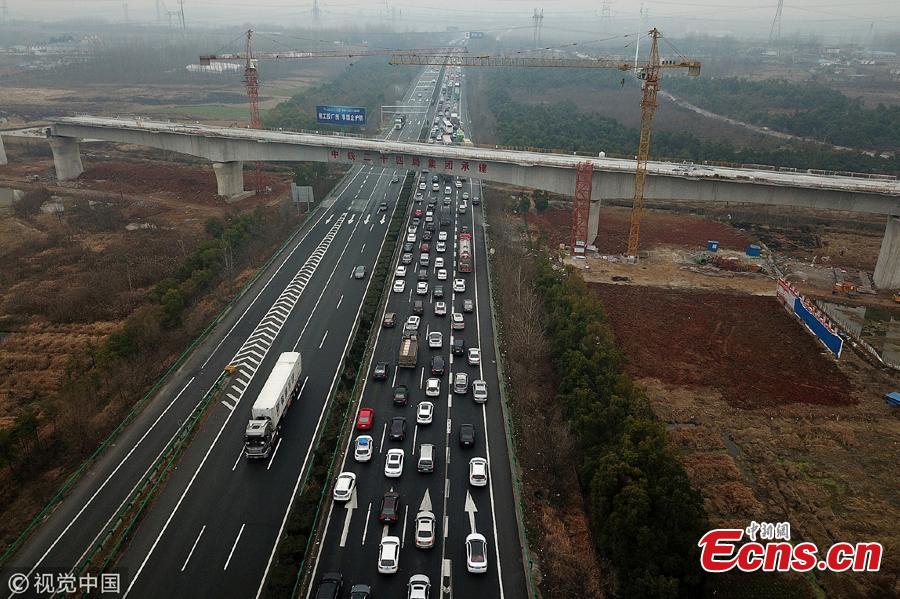 An aerial photo shows heavy traffic heading in one direction on an expressway while, in comparison, the opposite side of the road remains almost empty in Anhui Province. China is in the midst of its Spring Festival travel rush as millions of people go home for family reunions for the most important festival of the year. (Photo/VCG)