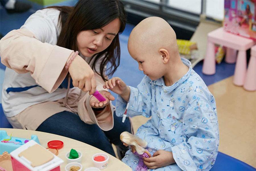 Xinyi plays house with a volunteer. (Photo provided to chinadaily.com.cn)