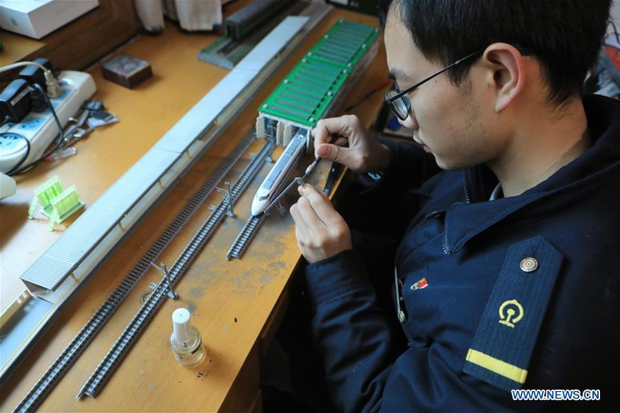Zhang Yuqi makes a model of a bullet train maintenance center at his home in Guiyang, capital of southwest China\'s Guizhou Province, Jan. 30, 2019. As a model train hobbyist, 27-year-old Zhang Yuqi has made and collected more than a hundred model trains. Zhang is also a bullet train mechanic responsible for checking bullet trains during the Spring Festival travel rush at a maintenance center in Guiyang of Guizhou Province. Despite heavy work load and work pressure, Zhang said he is dedicated to ensuring the safety of bullet trains. (Xinhua/Ou Dongqu)