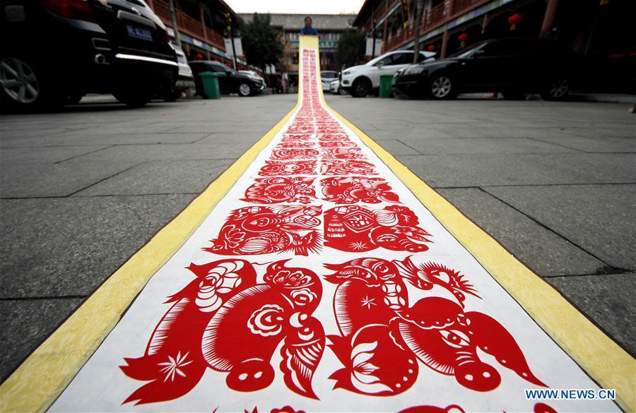 <?php echo strip_tags(addslashes(Folk artist Shi Hongxia shows a pig-themed paper cutting artwork in Tengzhou City, east China's Shandong Province, Jan. 31, 2019. Shi has spent two months to create the artwork, which is 9 meters long and features 100 pig figures, to greet the coming of the Year of the Pig. (Xinhua/Sun Zhongzhe))) ?>