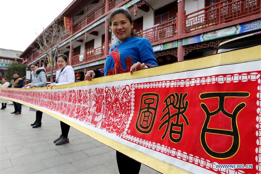 <?php echo strip_tags(addslashes(Folk artist Shi Hongxia (1st R) shows a pig-themed paper cutting artwork in Tengzhou City, east China's Shandong Province, Jan. 31, 2019. Shi has spent two months to create the artwork, which is 9 meters long and features 100 pig figures, to greet the coming of the Year of the Pig. (Xinhua/Sun Zhongzhe))) ?>
