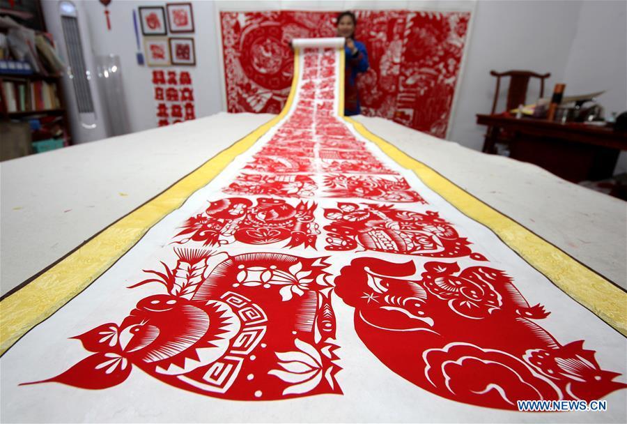 <?php echo strip_tags(addslashes(Folk artist Shi Hongxia shows a pig-themed paper cutting artwork at home in Tengzhou City, east China's Shandong Province, Jan. 31, 2019. Shi has spent two months to create the artwork, which is 9 meters long and features 100 pig figures, to greet the coming of the Year of the Pig. (Xinhua/Sun Zhongzhe))) ?>