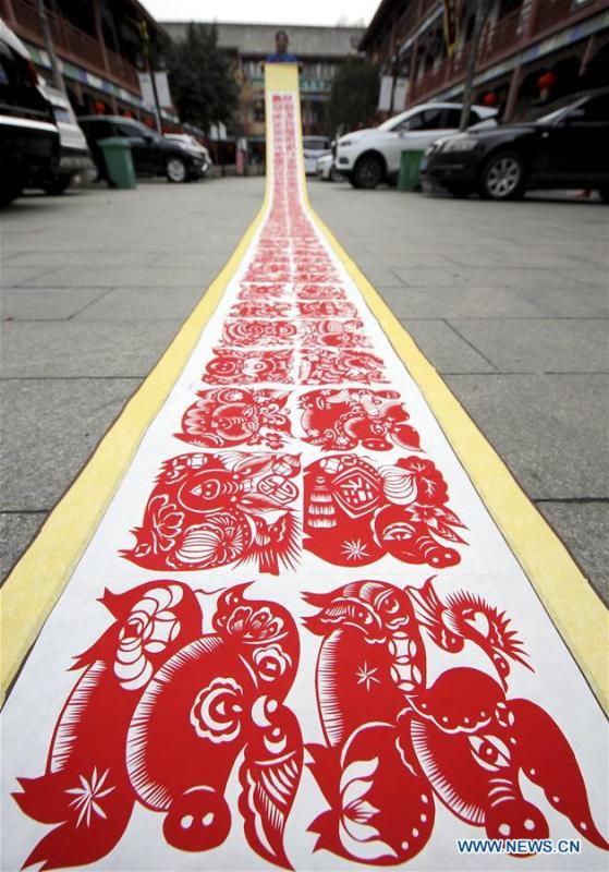 <?php echo strip_tags(addslashes(Folk artist Shi Hongxia shows a pig-themed paper cutting artwork in Tengzhou City, east China's Shandong Province, Jan. 31, 2019. Shi has spent two months to create the artwork, which is 9 meters long and features 100 pig figures, to greet the coming of the Year of the Pig. (Xinhua/Sun Zhongzhe))) ?>