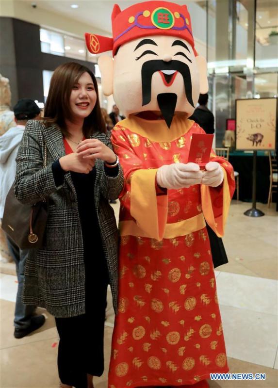 <?php echo strip_tags(addslashes(A woman poses with a staff member dressed up as the Chinese God of Wealth during a Chinese Lunar New Year celebration at South Coast Plaza in Costa Mesa, California, the United States, on Jan. 31, 2019. South Coast Plaza held a variety of activities such as dragon dance, lion dance, singing and dancing shows to celebrate the upcoming Chinese Lunar New Year. (Xinhua/Li Ying))) ?>