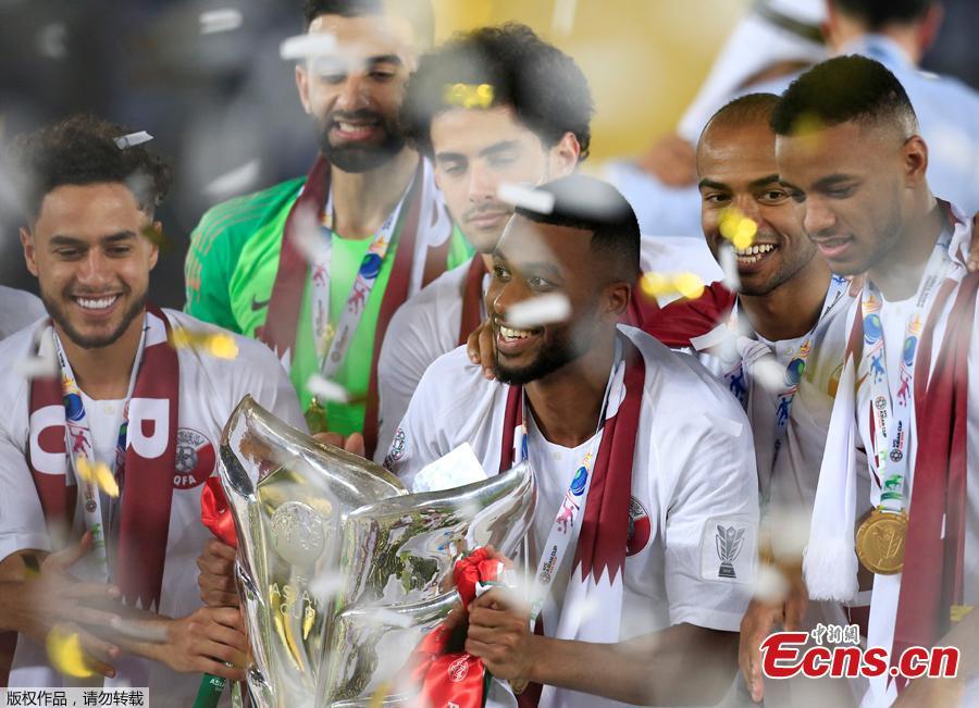 Qatar\'s Abdelaziz Hatim and team mates celebrate winning the Asian Cup with the trophy in Abu Dhabi, United Arab Emirates, February 1, 2019. Qatar stunned four-time champion Japan 3-1 to win the AFC Asian Cup for the first time as striker Almoez Ali scored his record-breaking ninth goal in the tournament on Friday. (Photo/Agencies)