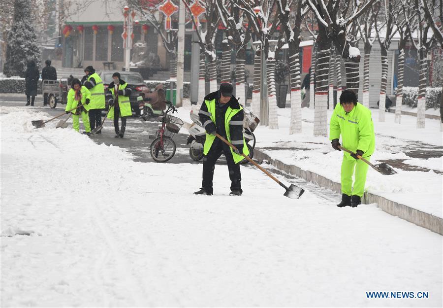 Sanitation workers sweep snow in the street in Jishan County in Yuncheng, north China\'s Shanxi Province, Feb. 10, 2019. Snowfall has hit many regions in the southern part of the province since Saturday.