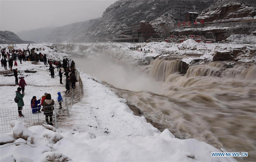 Tourists view the Hukou Waterfall of the Yellow River in snow in Jixian County, north China\'s Shanxi Province, Feb. 10, 2019. Snowfall has hit many regions in the southern part of the province since Saturday.