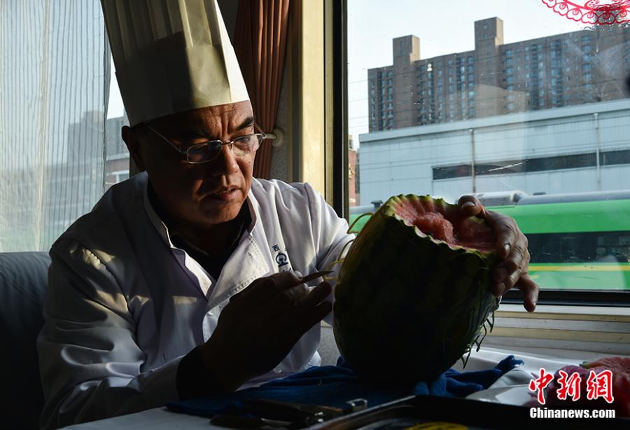 Wang Jinliang carves a watermelon on a train in Beijing during Spring Festival, China\'s Lunar New Year. Wang, 59, has worked on trains for more than 40 years, starting as a cook in 1978 before moving to roles as chef, kitchen head and now Party chief of the passengers service department. As the 2019 Spring Festival was his last one on duty, he spent 80 yuan ($12) buying fruits and vegetables including watermelon, carrot and Chinese cabbage to show his carving creations. Wang also said his skill in making fancy food garnishes enabled him to contribute to marking important occasions in his job, such as the first train from Beijing to Shenzhen in 1996. (Photo: China News Service/Zhai Lu)