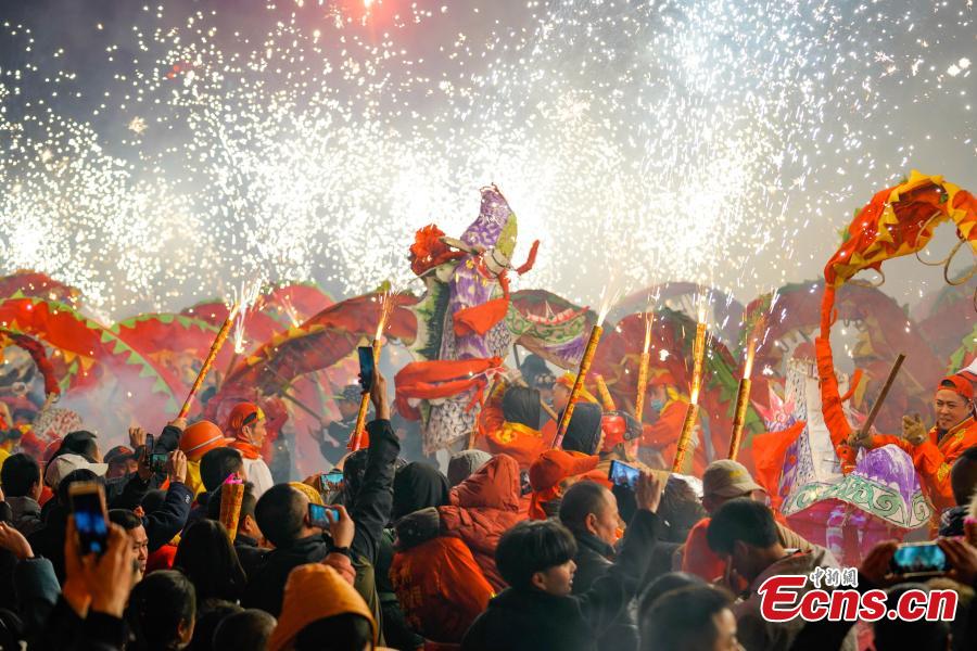 People perform dragon dance with a background of firecrackers in Yuqing County, southwest China\'s Guizhou Province, Feb. 16, 2019. Villagers gathered and performed dragon dances to celebrate the upcoming Lantern Festival,which falls on Feb. 19 this year.