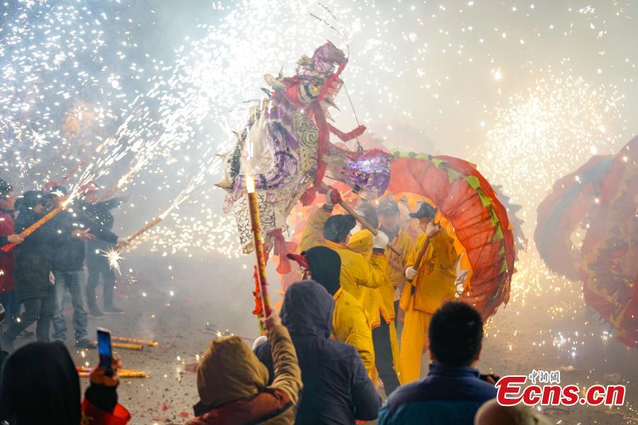 People perform dragon dance with a background of firecrackers in Yuqing County, southwest China\'s Guizhou Province, Feb. 16, 2019. Villagers gathered and performed dragon dances to celebrate the upcoming Lantern Festival,which falls on Feb. 19 this year.