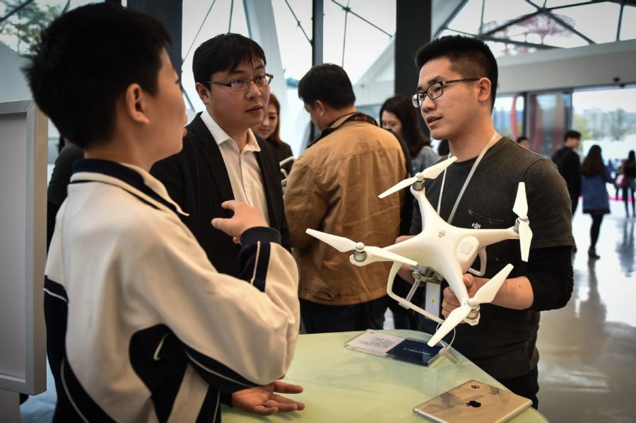 A employee of DJI, a Shenzhen, Guangdong province-based drone maker, addresses queries from visitors at one of the company\'s flagship stores. (Photo/Xinhua)