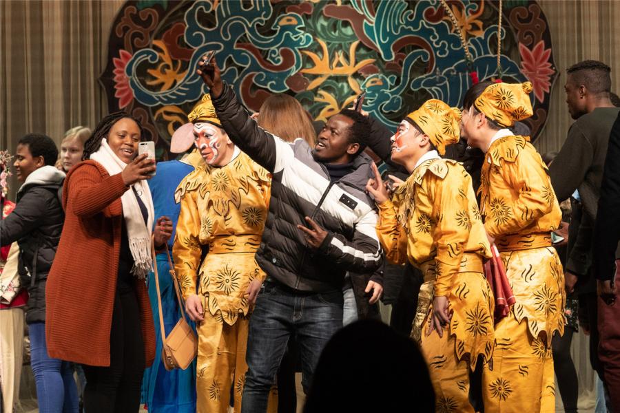 Students take selfies with the artists.  (Photo/chinadaily.com.cn)