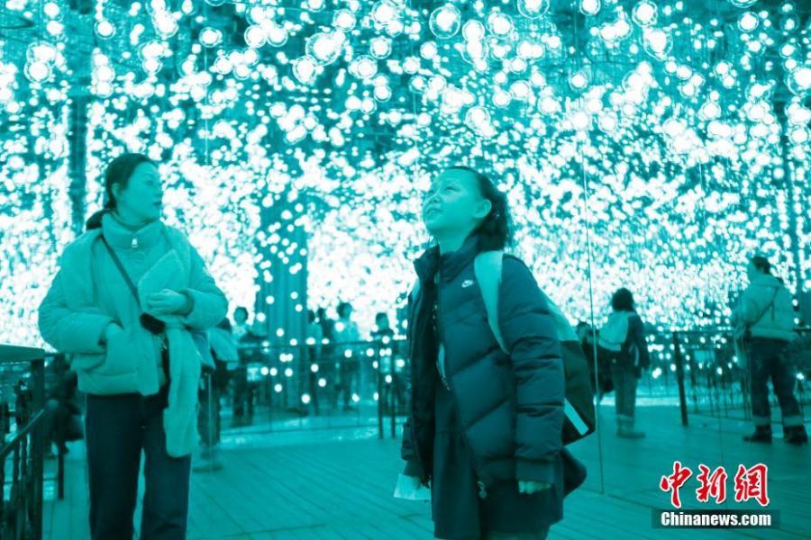 Visitors enjoy a light show on Central Avenue, a major shopping street in Harbin, Northeast China\'s Heilongjiang Province, Feb. 21, 2019. Combining technology with art, it offered interactive games for an immersive experience. (Photo: China News Service/Lyu Pin)