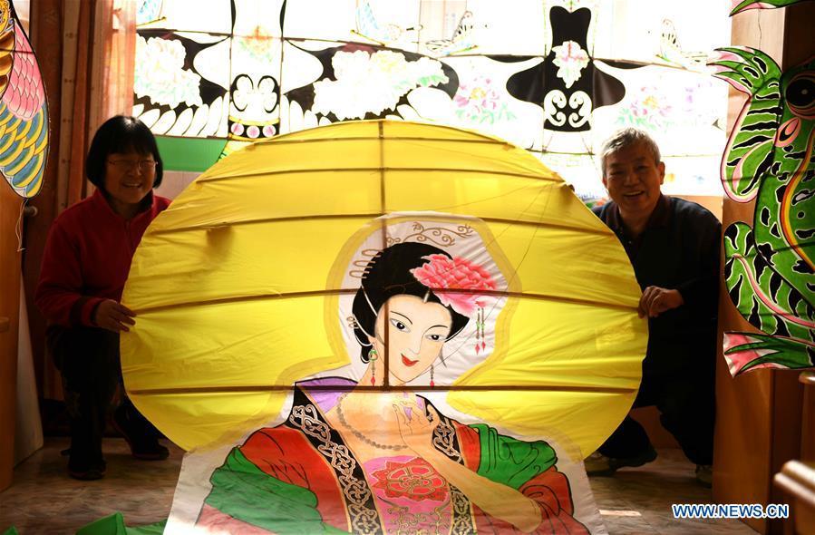 Kite enthusiasts Fu Xianming (R) and Lin Wenqing display one of their kites at home in Shijiazhuang, north China\'s Hebei Province, Feb. 20, 2019. Fu Xianming and his wife Lin Wenqing are known for their passion for kites. The retired school-teacher couple has completed more than 1,500 kites since they began to learn kite-making in 1998. Driven by a wish to master the kite-making crafts, Fu and Lin went on multiple study tours to Weifang, Shandong Province, where traditional Chinese kites originated. Besides enjoying themselves, the couple has also set up a campus workshop for local students who show interest in kite-making. (Xinhua/Chen Qibao)