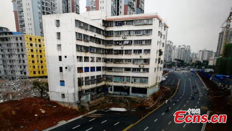 A holdout building is demolished in Haikou City, Hainan Province, Feb. 24, 2019. The eight-story building was left standing for three years due to disagreements over compensation, affecting traffic and the urban landscape. The local government finally reached agreement with homeowners who agreed to relocate.  (Photo: China News Service/Huang Yixiao)