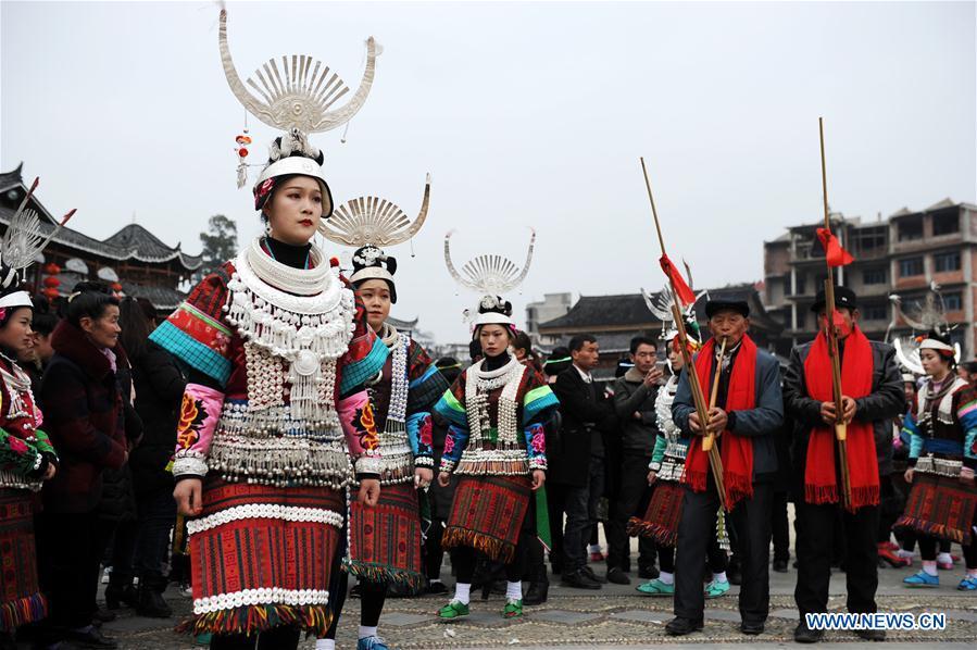 People in traditional costumes perform the lusheng dance in Zhouxi Town, Kaili City of southwest China\'s Guizhou Province, Feb. 24, 2019. The ethnic Miao girls donning traditional embroidered attire and silver ornaments sing and dance to the sound of the lusheng, a reed-pipe wind instrument, to pray for a good harvest. Ethnic Miao people get together at Gannangxiang to rejoice in the annual Gannangxiang celebration, one of the largest-scale and most primitive Miao lusheng celebrations in Guizhou Province. (Xinhua/Yang Wenbin)