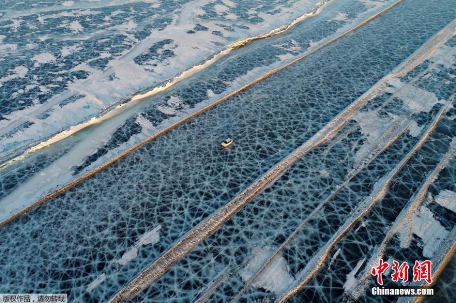 A car drives on the frozen surface of the Yenisei River, which looks like a spider web, in southern Krasnoyarsk, Russia, March 3, 2019. (Photo/IC)