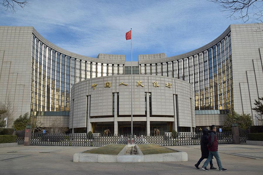 Pedestrians walk past the People\'s Bank of China, the central bank, in Beijing. (Photo by Zhang Gang/for China Daily)
Key points:

-- Enterprises under all forms of ownership will be treated on an equal footing.

-- Prudently advance legislation on real estate tax.

-- Reform and improve the structure of the financial system, and develop private and community banks, to better serve the real economy.