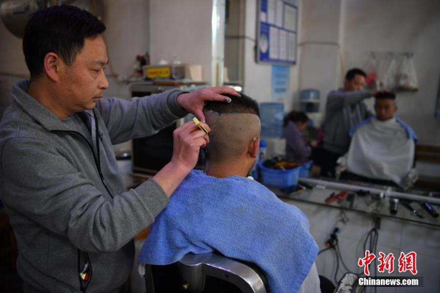 A man gets a haircut in Kunming City, Southwest China\'s Yunnan Province, March 8, 2019. March 8 marks traditional Chinese festival Long Tai Tou (dragon head raising), which refers to the start of spring and farming. During the festival, held on the second day of the second month of the lunar calendar, people play dragon lanterns, eat noodles, shave their hair, and pray for luck. (Photo: China News Service/Liu Ranyang)