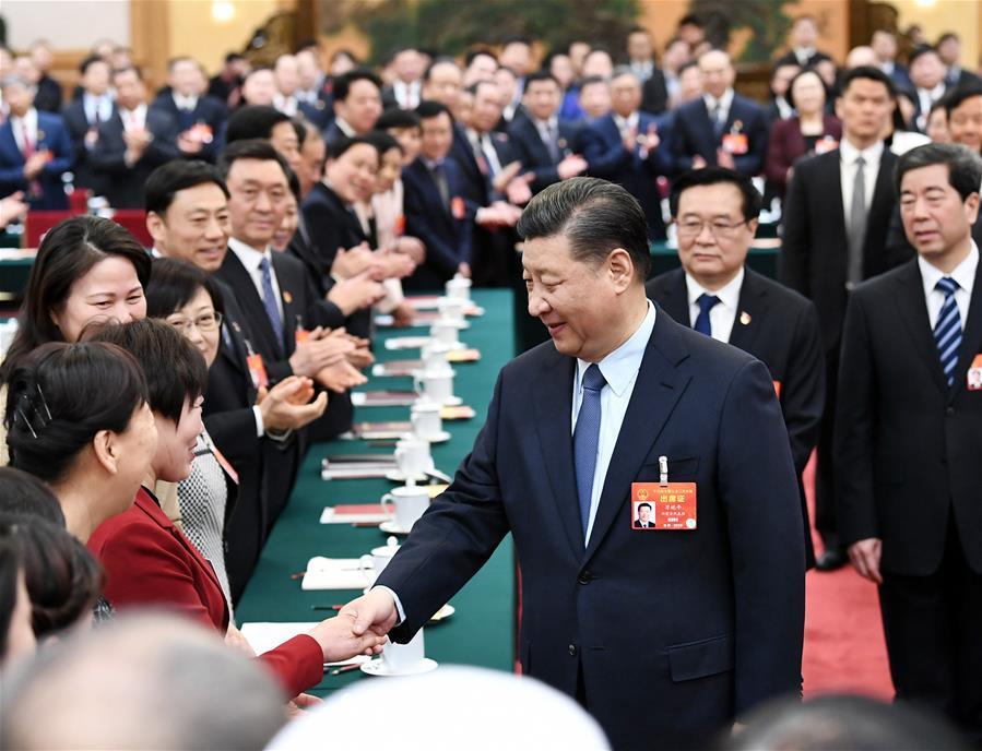 Chinese President Xi Jinping, also general secretary of the Communist Party of China (CPC) Central Committee and chairman of the Central Military Commission, shakes hands with a female deputy when joining deliberation with deputies from central China\'s Henan Province at the second session of the 13th National People\'s Congress in Beijing, capital of China, March 8, 2019. Xi extended greetings and best wishes to female lawmakers, political advisors and staff workers at the ongoing \