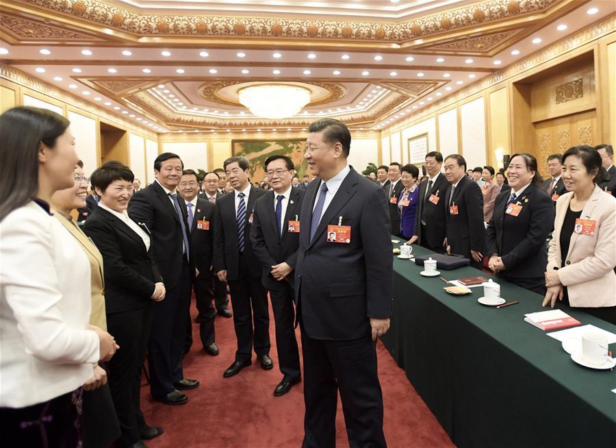 Chinese President Xi Jinping, also general secretary of the Communist Party of China (CPC) Central Committee and chairman of the Central Military Commission, talks with female deputies when joining deliberation with deputies from central China\'s Henan Province at the second session of the 13th National People\'s Congress in Beijing, capital of China, March 8, 2019. Xi extended greetings and best wishes to female lawmakers, political advisors and staff workers at the ongoing \