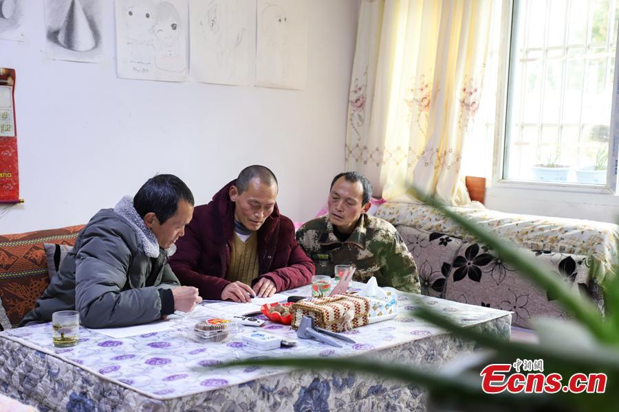 Triplet brothers Zhang Hua (L), Zhang Jian, and Zhang Zhong prepare an inspection report in the Gonglongping state-owned tree farm in Bijie City, Guizhou Province, March 10, 2019. Influenced by their father, the three brothers began to work as rangers in the farm in 1981. The tree farm covers an area of 53,300 mu (3,553 hectares) and the brothers usually walk approximately 30 kilometers on average per working day. Guizhou has about 3,000 registered rangers who work in tree farms totalling 5.55 million mu. (Photo: China News Service/Qu Honglun)