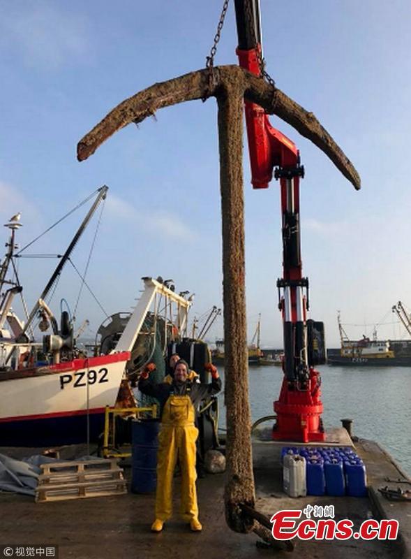 The fishing crew who netted the anchor from what might be the world\'s most valuable shipwreck display their find.  (Photo/VCG)