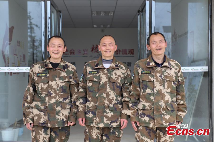 Triplet brothers Zhang Jian (front), Zhang Zhong (center), and Zhang Hua pose for a photo in front of their office building in Bijie City, Guizhou Province, March 10, 2019. Influenced by their father, the three brothers began to work as rangers in the farm in 1981. The tree farm covers an area of 53,300 mu (3,553 hectares) and the brothers usually walk approximately 30 kilometers on average per working day. Guizhou has about 3,000 registered rangers who work in tree farms totalling 5.55 million mu. (Photo: China News Service/Qu Honglun)