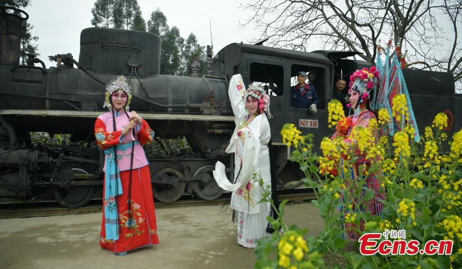 Tourists don traditional costumes to pose for a photo with the Jiayang steam train in Jianwei County, Southwest China’s Sichuan Province, March 12, 2019. The Jiayang steam train, which has been running for half a century and still operates on old narrow-gauge tracks, is a major contributor to the local tourism industry. (Photo: China News Service/Liu Zhongjun)